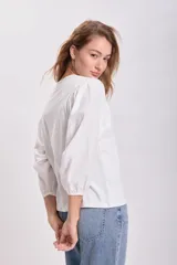 Remera blanca de mangas 3/4 abullonadas.