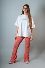 Calza tipo oxford confeccionada en lycra de malla estampada con motivos geométricos en color naranja y lila.