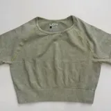 Remera deportiva verde con efecto tie-dye, de corte cropped y mangas cortas.