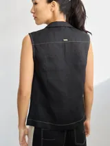 Chaleco negro con cuello solapa, abotonado al frente y con pespuntes en color crudo.