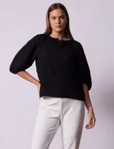 Blusa blanca de gasa marca Sioni, con cuello a la base y escote en V con botones.