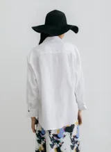 Camisa negra de lino con corte recto, cuello clásico, mangas largas y abertura en los laterales.