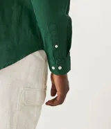 Camisa de lino negra de manga larga, con cuello camisero y abotonadura frontal.
