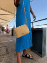 Bandolera pequeña color negro, de material símil cuero, con correa fina y herrajes plateados.