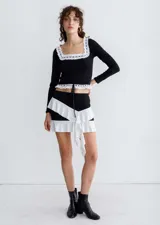 Minifalda negra con volados blancos diagonales.