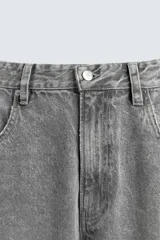 Pantalón de jean gris con efecto lavado, corte amplio tipo balloon fit, tiro medio, cinco bolsillos y cierre frontal con cremallera y botón.