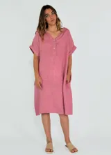 Vestido midi rosado de lino, corte recto, con cuello en V, mangas cortas con dobladillo y bolsillos laterales.