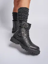 Bota corta de cuero negro con dos correas con hebillas metálicas y suela track.