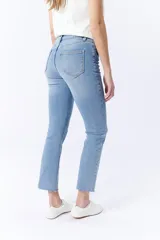Pantalón de jean celeste con corte cropped flare y ruedo desflecado.