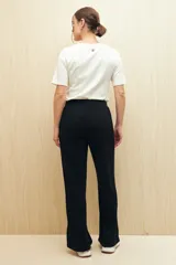Pantalón negro de punto, corte suelto, con elástico en la cintura y aberturas en el ruedo.