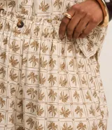 Short femenino modelo runner confeccionado en viscolino con cintura elástica, botón delantero, bolsillos y estampa de palmeras.