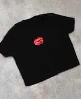 Remera corta negra con estampado de labios rojos en el centro.