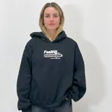 Buzo hoodie negro de felpa con calce boxy fit y estampa frontal con el texto "Feeling" en blanco.