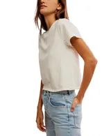 Remera blanca de algodón, semicorta y encogida, con corte holgado, mangas cortas y cuello redondo.