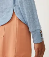 Blusa celeste de viscosa con cuello redondo, mangas largas y puños con botones.