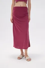Falda midi color borgoña, de corte tubo y frunces laterales.