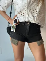 Short de jean negro con detalle de tela a cuadros en los laterales.