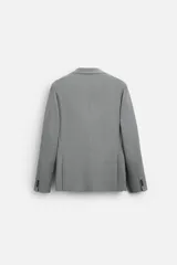Blazer straight fit color gris claro confeccionado en tejido con viscosa. Tiene cuello con solapas de muesca, manga larga acabada en puño con botón, bolsillo de vivo en pecho, bolsillos de plastrón en cadera y bajo con aberturas en espalda. Cierre frontal de botonadura.