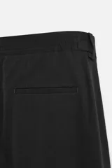 Pantalón negro de corte recto confeccionado en tejido fluido con mezcla de viscosa, con bolsillos frontales y traseros de vivo.