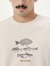 Camiseta blanca de algodón con cuello redondo y mangas cortas. Estampa rectangular con borde negro que contiene la frase "NATURAL ATMOSPHERE" en letras mayúsculas y una imagen de montañas y mar.