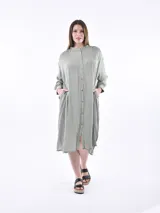Vestido midi tipo camisero con estampado de rayas verticales en tonos verde y blanco, cuello mao, manga larga y bolsillos laterales.
