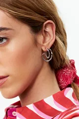 Aros plateados con forma de argolla irregular y textura ondulada.