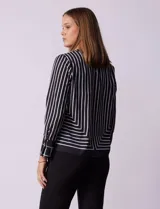Blusa de gasa estampada a rayas verticales blancas y negras, marca Sioni. Tiene espalda con abertura y botón, y mangas largas con puño y botón.