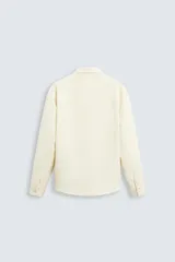 Sobrecamisa negra de tejido con elasticidad, cuello solapa, manga larga con puño abotonado, bolsillos de plastrón en el pecho y cierre frontal con botones a presión.