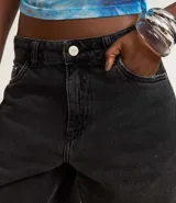 Bermuda femenina confeccionada en jeans color gris oscuro, modelo jorts, con trabillas en la cintura y bolsillos.