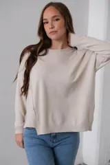 Sweater beige de punto, corte recto, cuello redondo y detalle de botones en el lateral.