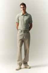 Remera polo verde claro en tejido de punto de algodón liviano, de corte ajustado, con cuello clásico, tapeta de botones y mangas cortas.