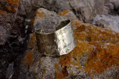 Brazalete ancho de bronce macizo con textura irregular.
