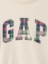 Remera blanca de algodón con cuello redondo y mangas largas. Estampado frontal con el logo de Gap en color azul marino.