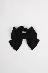 Scrunchie negro con moña grande del mismo material.