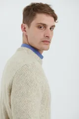 Sweater de punto trenzado color verde claro, con cuello redondo y mangas largas.