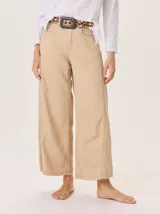 Pantalón ancho color beige, de corte holgado con costuras visibles en el frente y los laterales.