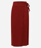 Pollera midi color rojo oscuro, estilo sobre con traspaso delantero que se ajusta con un lazo lateral de tiras finas. Presenta una cintura estructurada y un detalle de encaje discreto formado por la superposición de las capas.