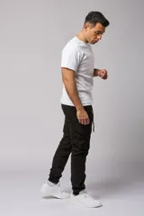 Pantalón cargo color beige de gabardina, con corte ajustado, bolsillos laterales con fuelle y puños elásticos en los tobillos.