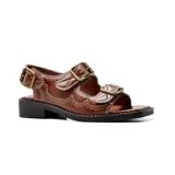 Sandalias bajas de cuero sintético color blanco hueso, con tres tiras horizontales con hebillas metálicas plateadas.