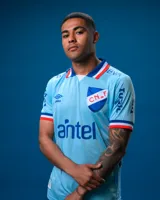 Camiseta de fútbol Umbro del Club Nacional de Football, modelo Alternativa 3. Diseño celeste con detalles en blanco y rojo en cuello y mangas. Incluye logo de Umbro, escudo del club y sponsor Antel en el frente.