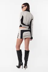 Minifalda deportiva gris con recortes laterales en negro y logo estampado en la parte trasera.