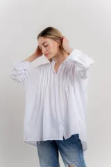Camisa oversize blanca de algodón con pliegues frontales.