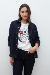 Remera blanca de manga corta con cuello redondo y un estampado frontal de flores y follaje en tonos rojo, azul marino y blanco.