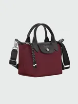 Bolso pequeño tipo tote o bandolera Longchamp modelo Le Pliage Energy XS, color borgoña (vino tinto), con asas cortas negras y correa larga ajustable negra.