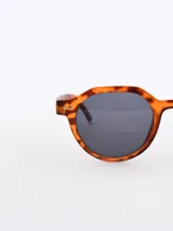 Lentes de sol con montura redonda de carey y cristales negros.