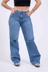 Pantalón de jean celeste de corte wide leg con roturas en las rodillas.