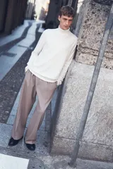 Polera blanca de punto fino, con cuello alto, mangas largas y corte ajustado.