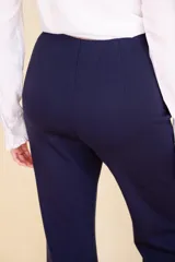 Pantalón de vestir negro con corte Oxford, tela suave al tacto con caída, cierre invisible y pinzas verticales. Confeccionado en 66% viscosa, 29% poliamida y 5% elastano.