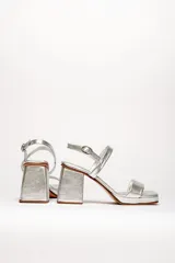Sandalias plateadas de cuero vacuno con dos tiras horizontales y pulsera con hebilla. Tacón cuadrado de 8 cm y plataforma de 2 cm.