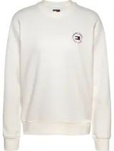 Buzo color blanco hueso de algodón con cuello redondo y corte regular. Presenta un pequeño logo circular de Tommy Jeans bordado en el pecho, con el nombre de la marca y la frase 'new york'.